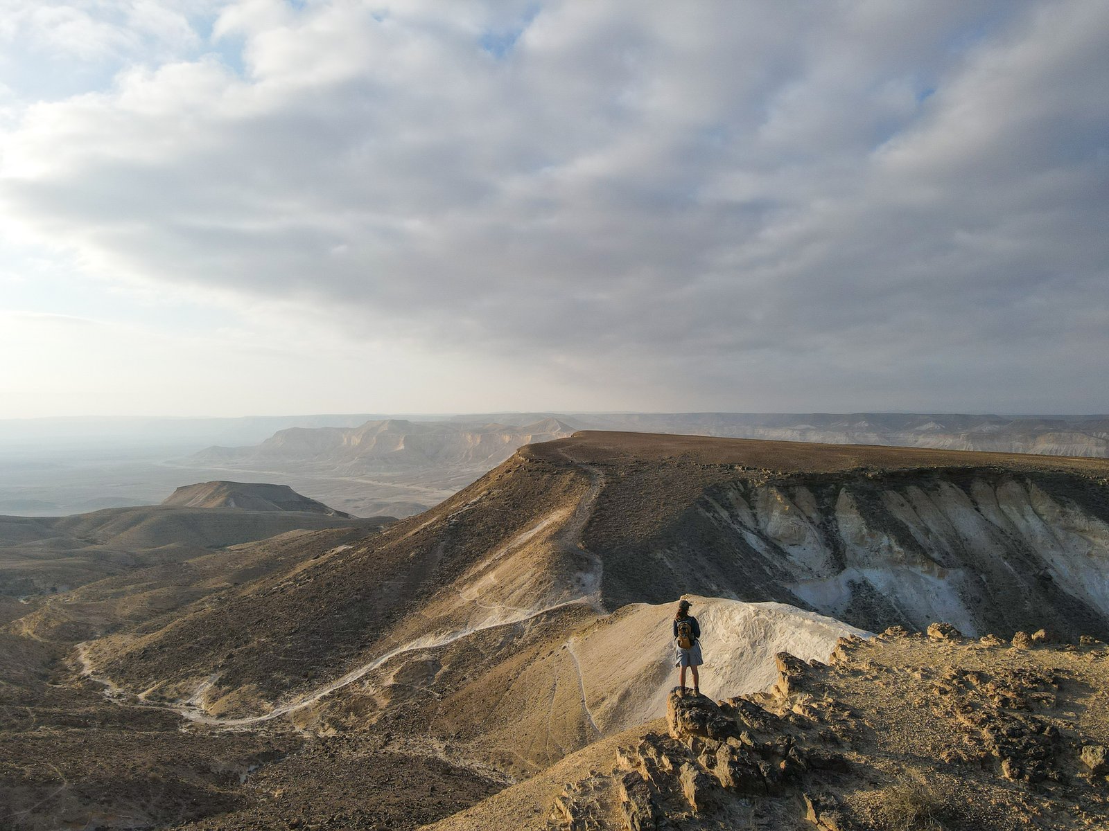 A figure on a cliff edge in the Negev