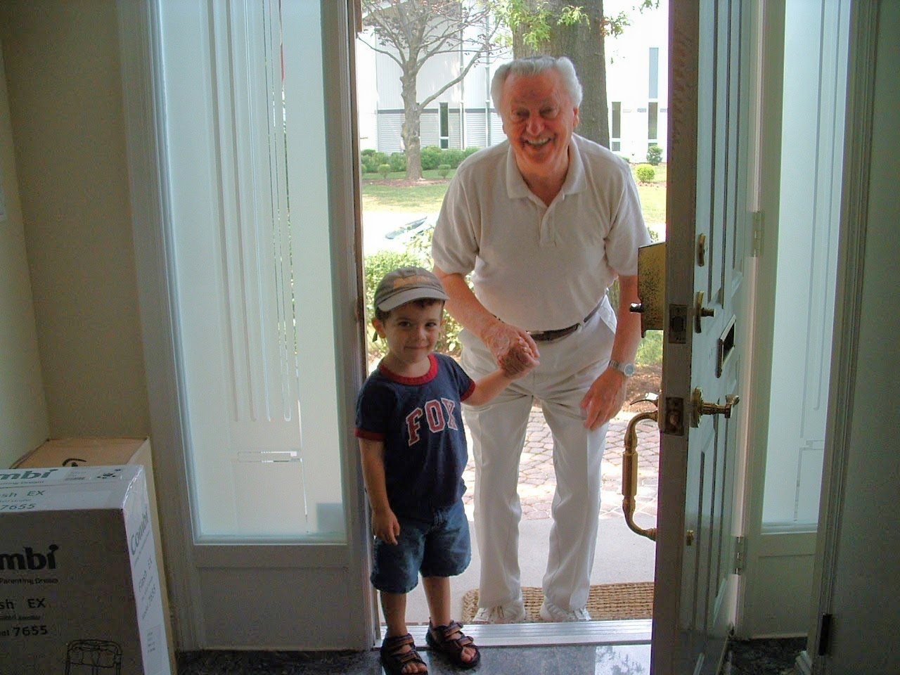 Papa with a young Eitan at the doorway, holding hands